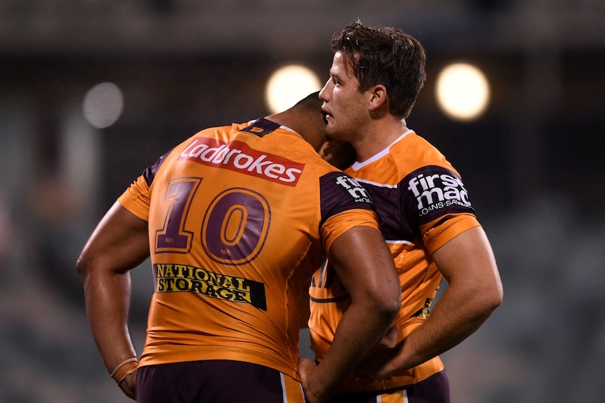 Two Brisbane Broncos NRL players lean on each other after losing a match to the Raiders in Canberra.