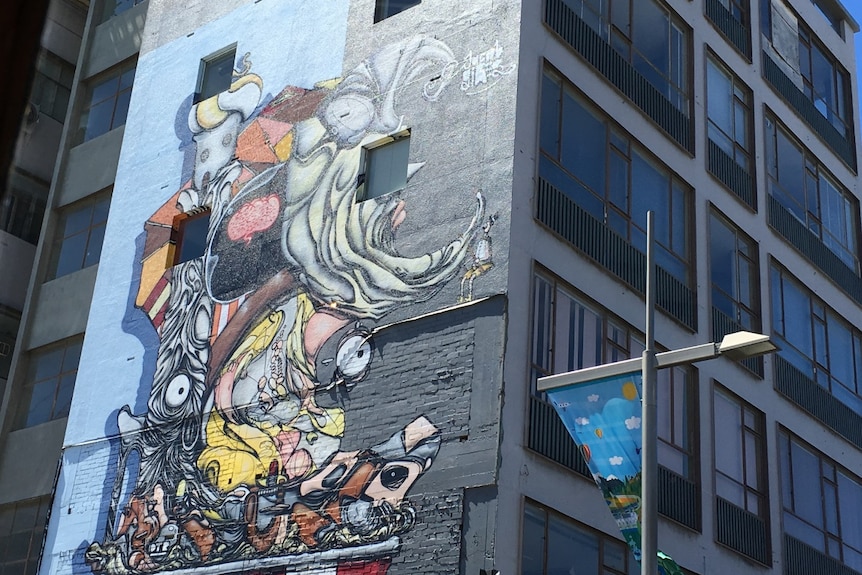 An abstract image of a series of faces with multiple eyes is painted on a wall in Christchurch, New Zealand.