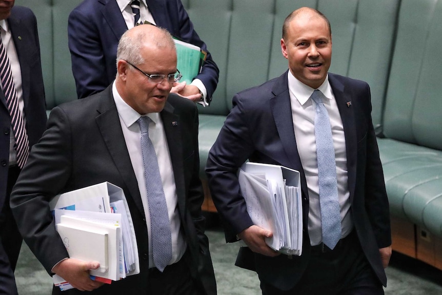 Scott Morrison and Josh Frydenberg, both holding stacks of folders, smile as they walk through the House of Reps.