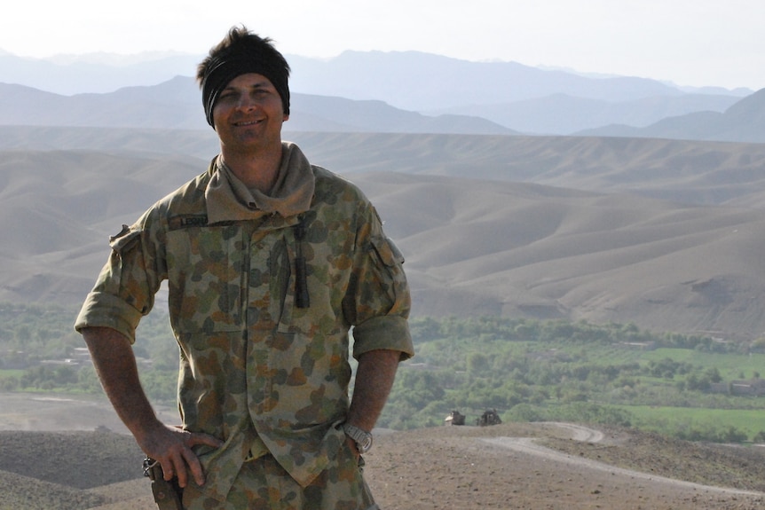 Image of a man in army equipment on top of a hill.  