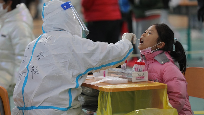 A staff member takes a swab sample from a child for nucleic acid test in Shenyang.