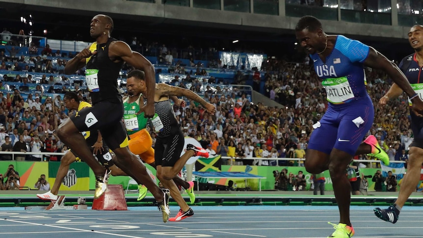 Jamaica's Usain Bolt (L) crosses the line to win the men's 100 metre final at the Rio Olympics.