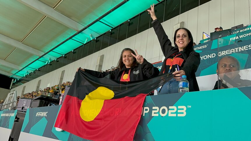 Two women with an Aboriginal flag