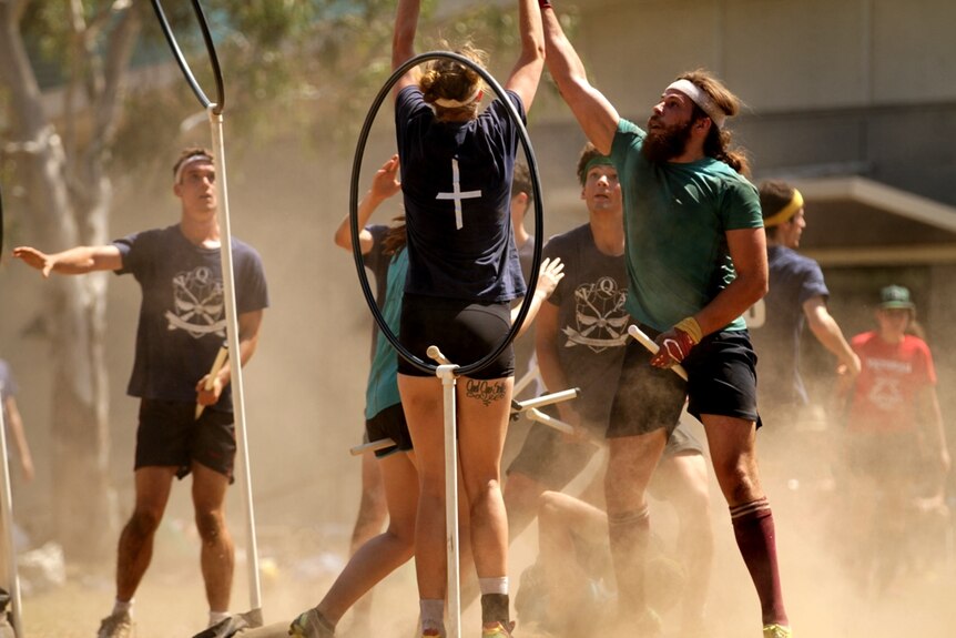 men and women battle it out on the quidditch field during a state of origin match