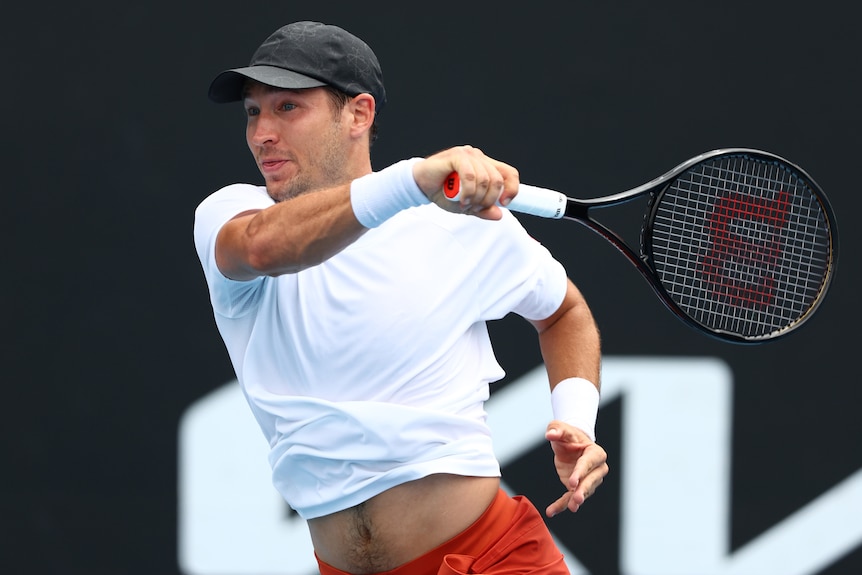 A Serbian male tennis player hits a forehand at the Australian Open.