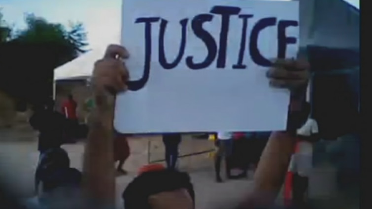 Man holding a 'freedom' sign inside the Nauru detention centre.