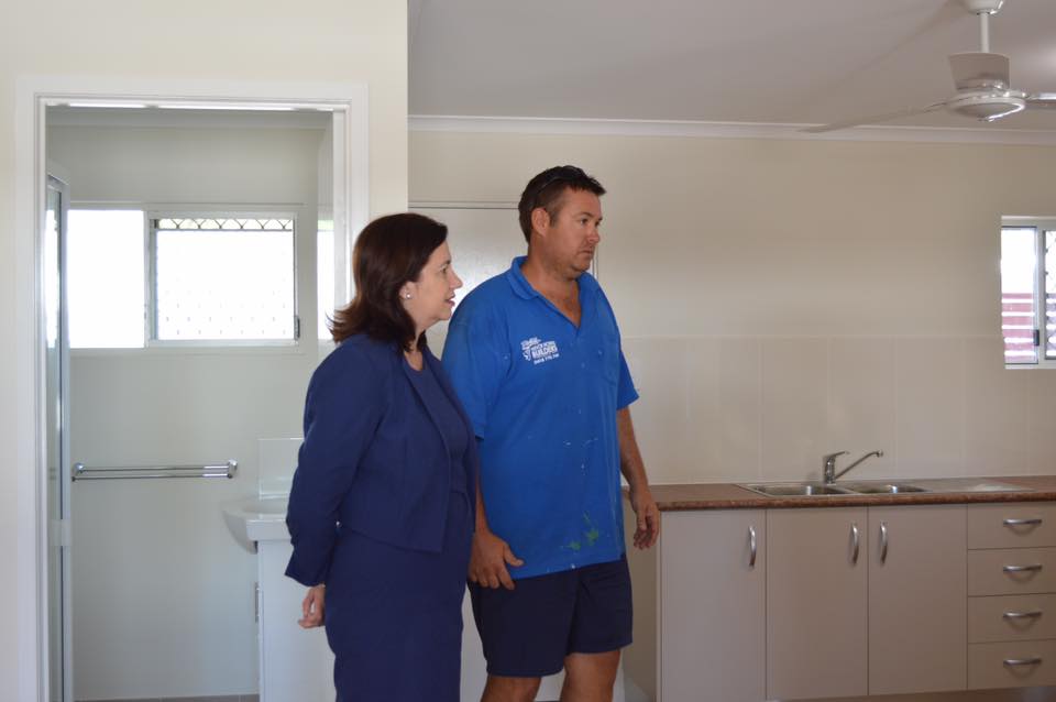 Queensland Premier Annastacia Palaszczuk stands next to a builder