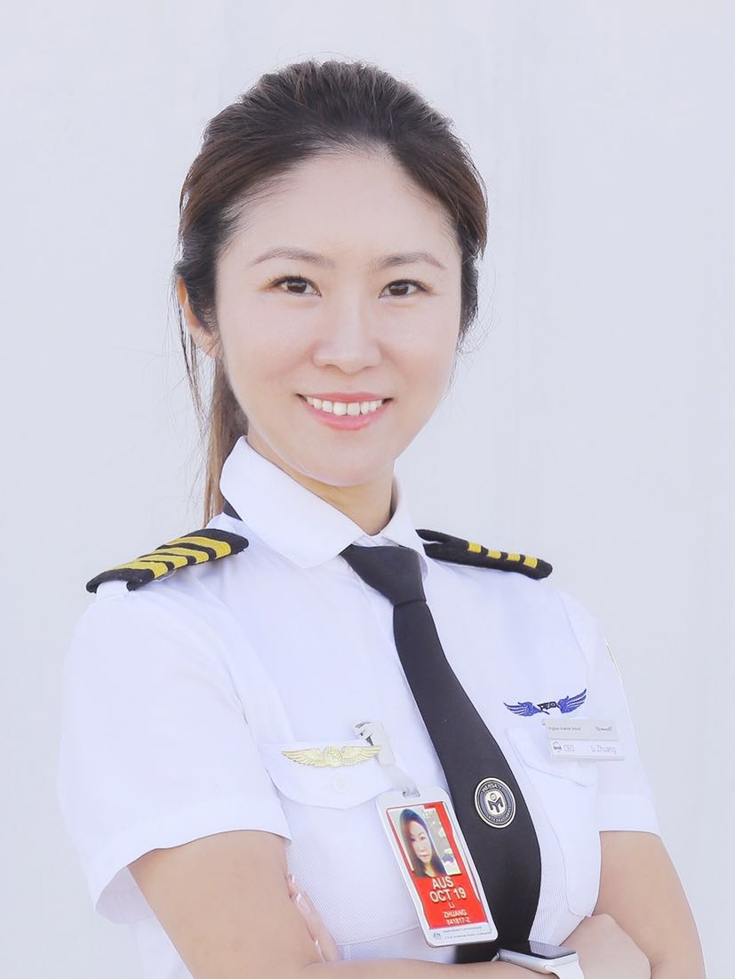 Li Zhuang smiles with arms crossed while wearing pilot uniform.