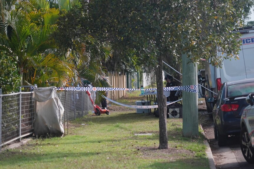 Police tape cordoning off a suburban property.