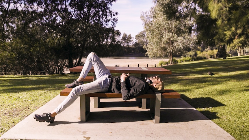 Man lying on park bench depicting our tips for 7 easy ways to start meditating