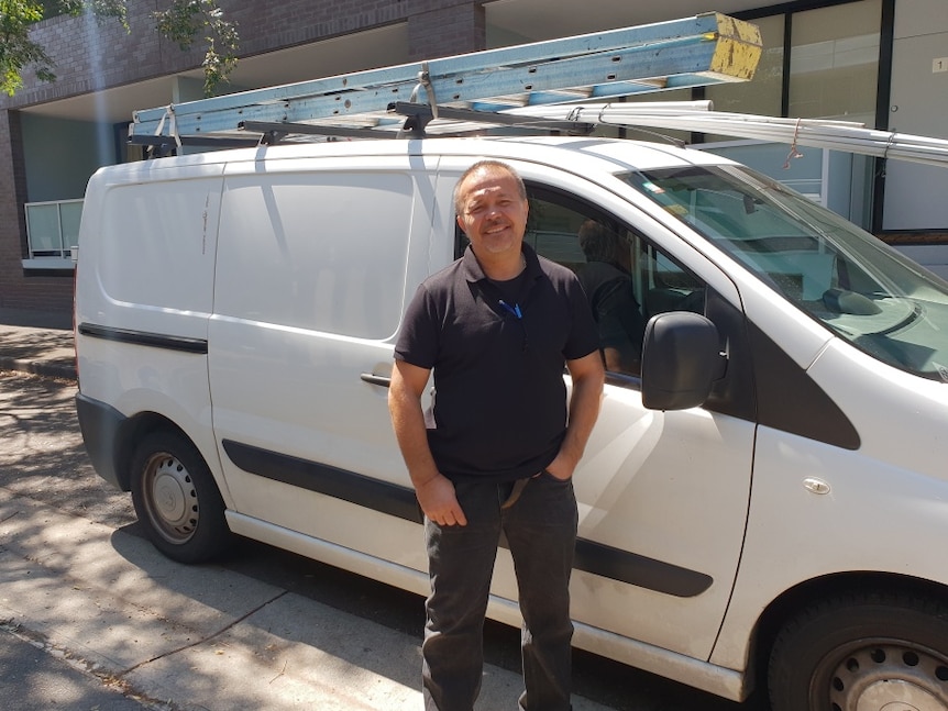 Property investor Michael Ilieff stands in front of his white van.