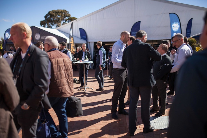 Delegates stand talking outside the annual Diggers and Dealers conference in Kalgoorlie, WA.