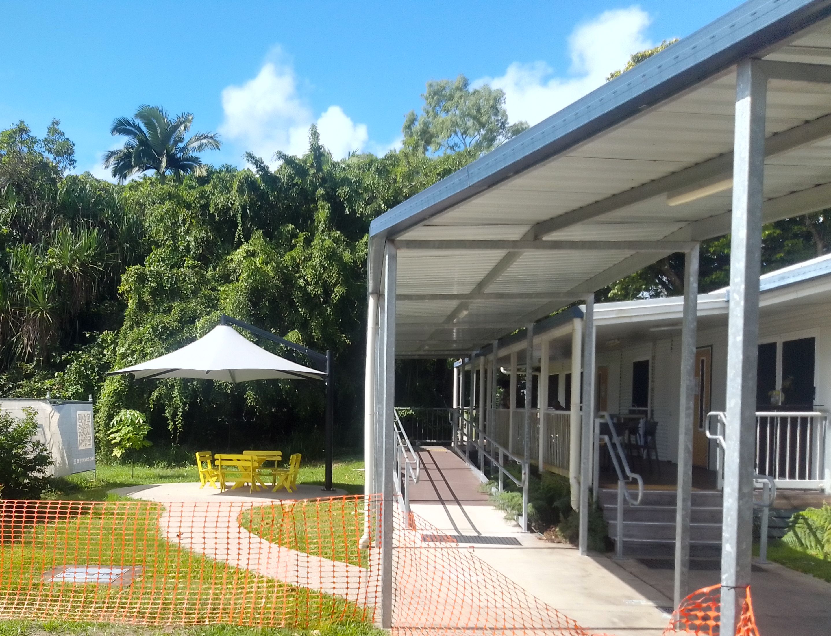 Skyspan umbrella at Cairns School of Distance Education on left, school building with ramps on right