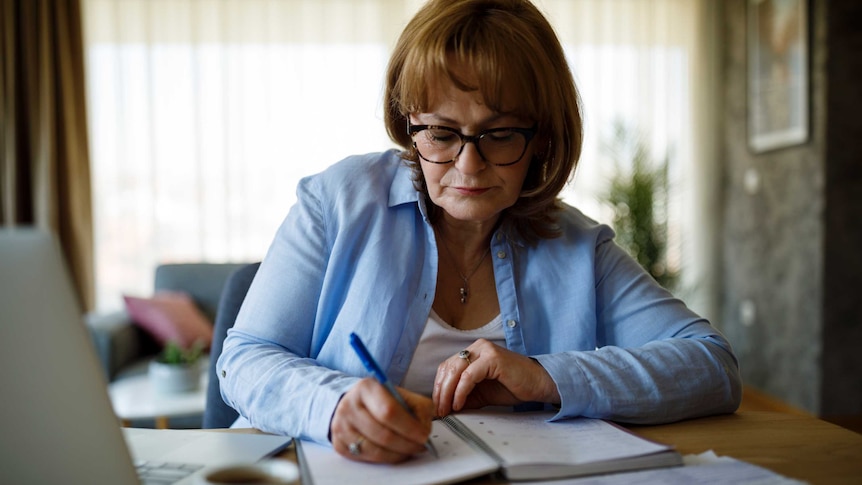 Woman working on computer on kitchen table