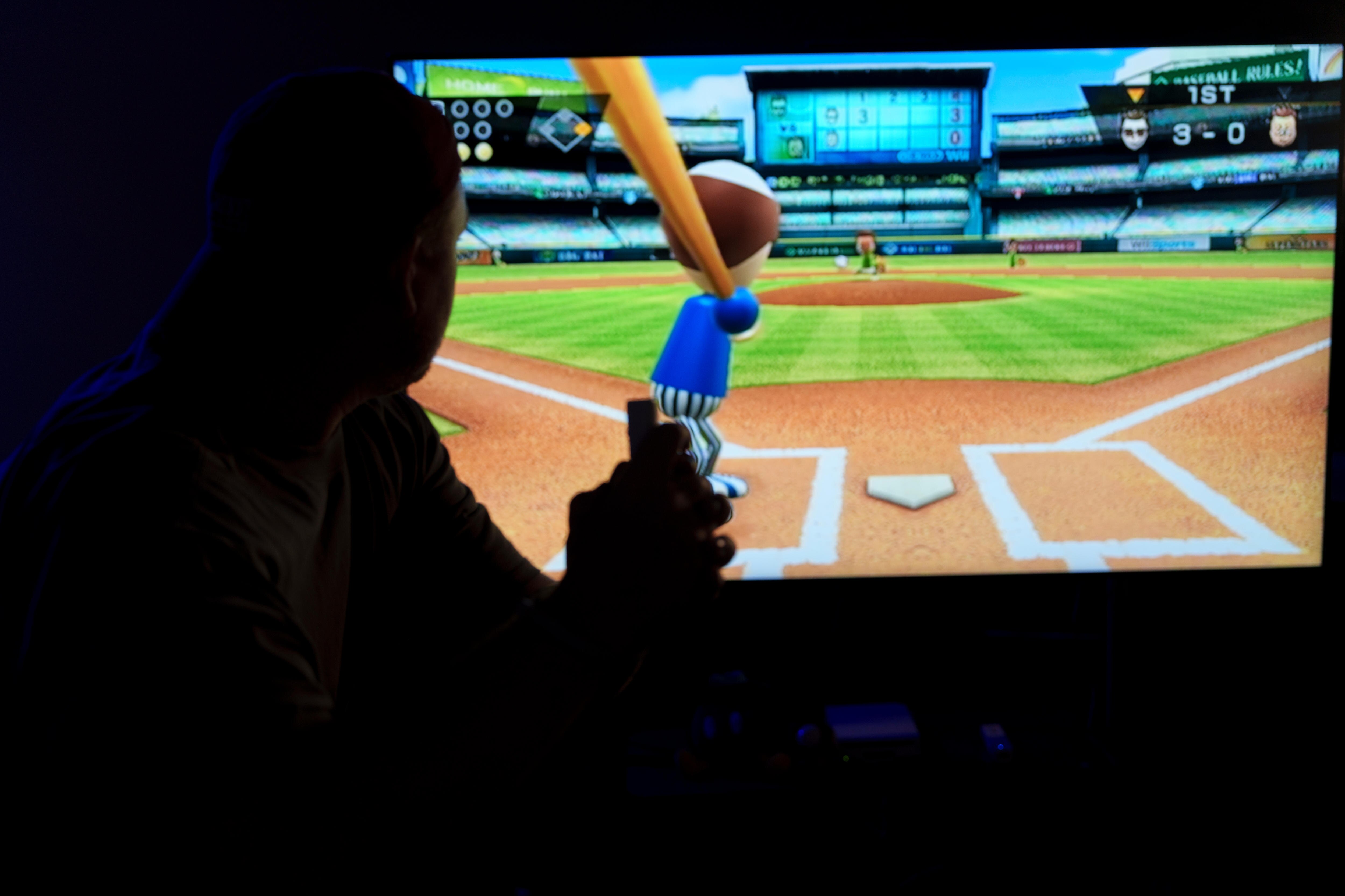 A silhouette of player playing Wii Sports Baseball. 