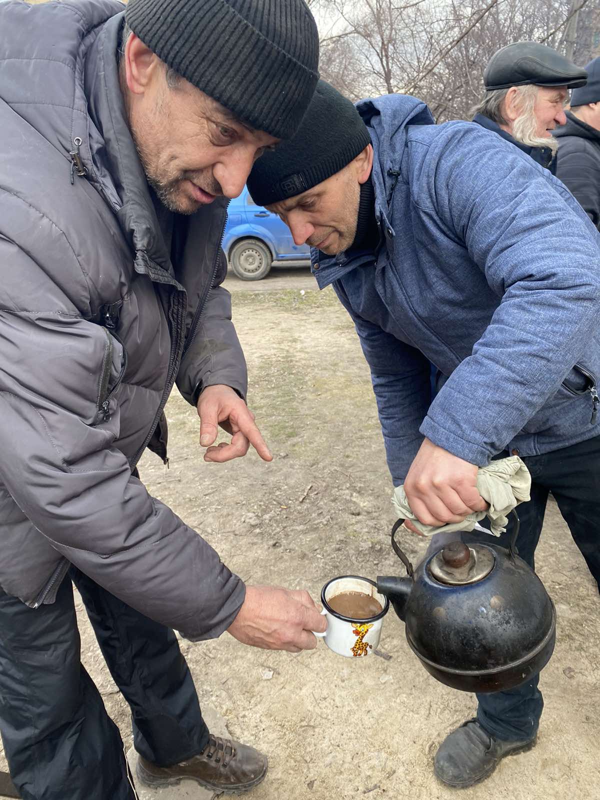 Two men share tea as they flee from Mariupol. 
