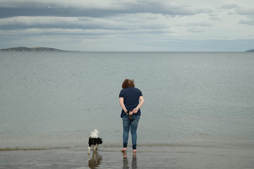 A woman at the beach with a dog.