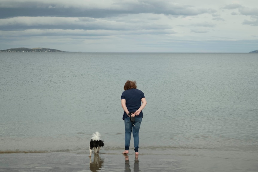 A woman at the beach with a dog.