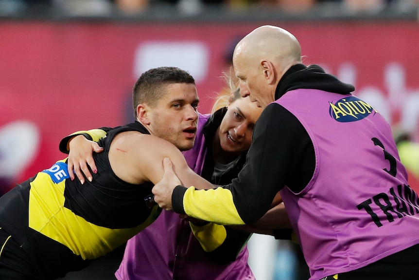 Dion Prestia looks groggy while being attended to by Richmond medical staff