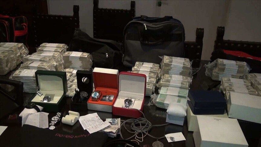 Wads of cash and wristwatches on display.