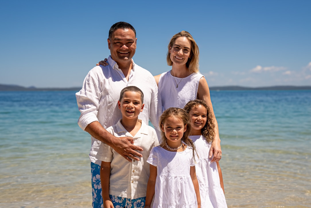 Kelvin Kong posa para una foto en la playa con su esposa e hijos.