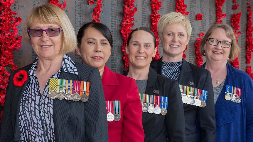 Five Australian servicewomen wearing their medals on the left side of their uniform.