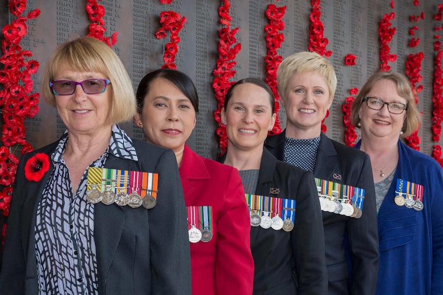 Five Australian servicewomen wearing their medals on the left side of their uniform.