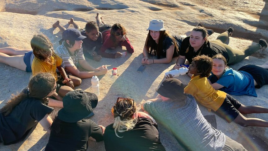 Students from Bunbury and Yandeyarra schools lie together on a large rock near the remote community.