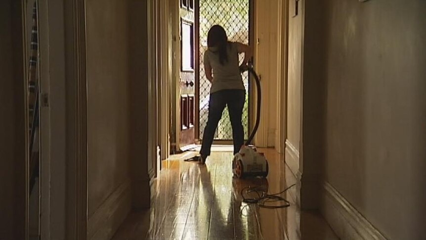 Unidentified woman vacuuming in a house. Good generic.
