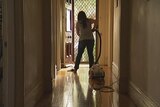Unidentified woman vacuuming in a house. Good generic.