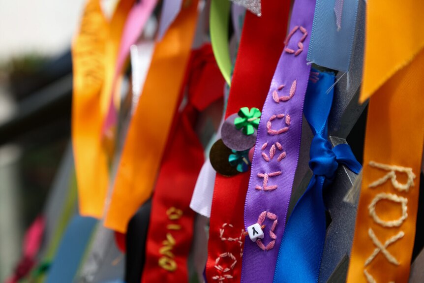 a close up shot of ribbons emrboidered with the names of loved ones