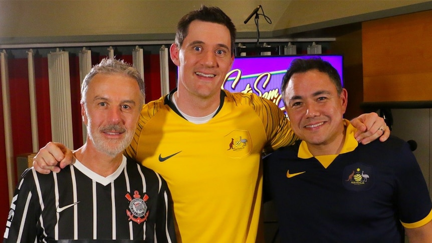 Santo Cilauro, Ed Kavalee and Sam Pang standing together in a radio studio.