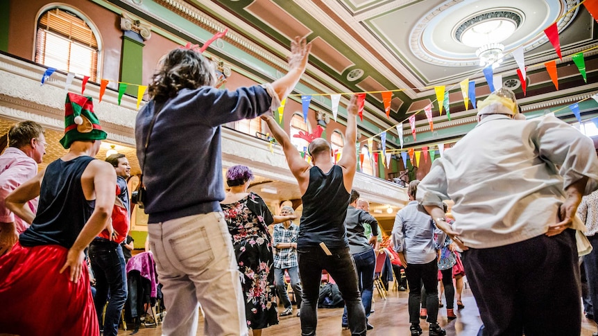 A group of people dancing in a hall