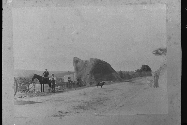 black and white picture of a rock on a road