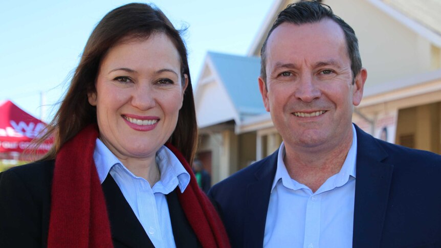Tania Lawrence and Mark McGowan pose for a photo smiling at the camera outdoors.