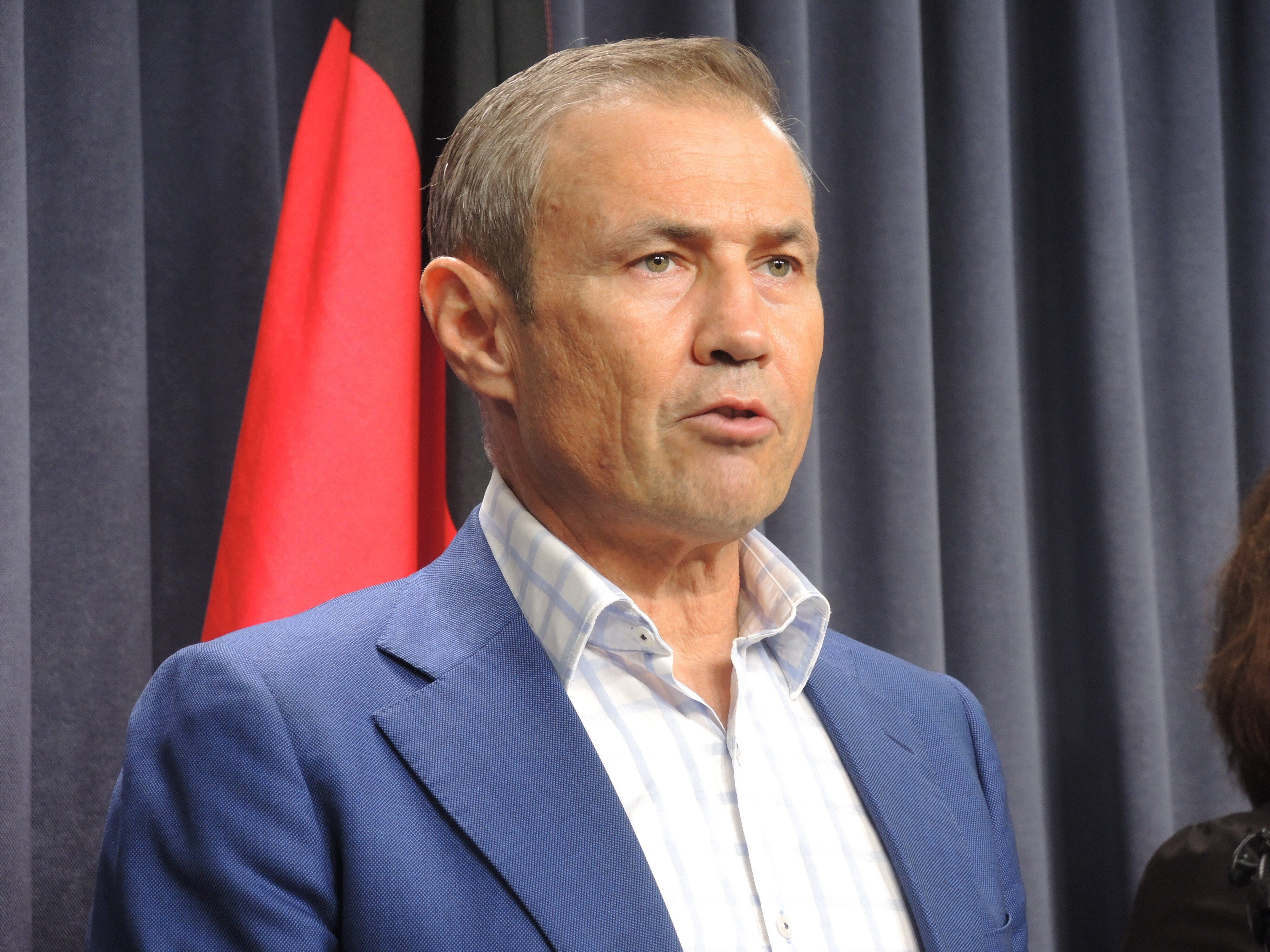 A head and shoulders shot of Roger Cook speaking at a media conference.