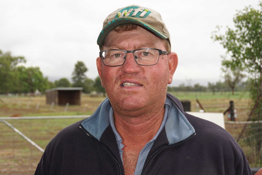 A man wearing a cap smiling at the camera.