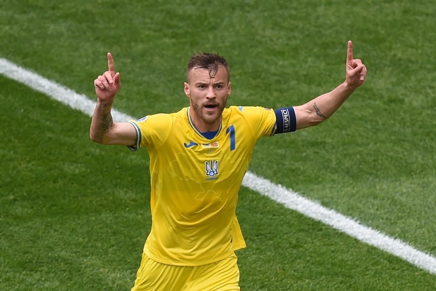 Andriy Yarmolenko holds both hands up in the air and points his fingers