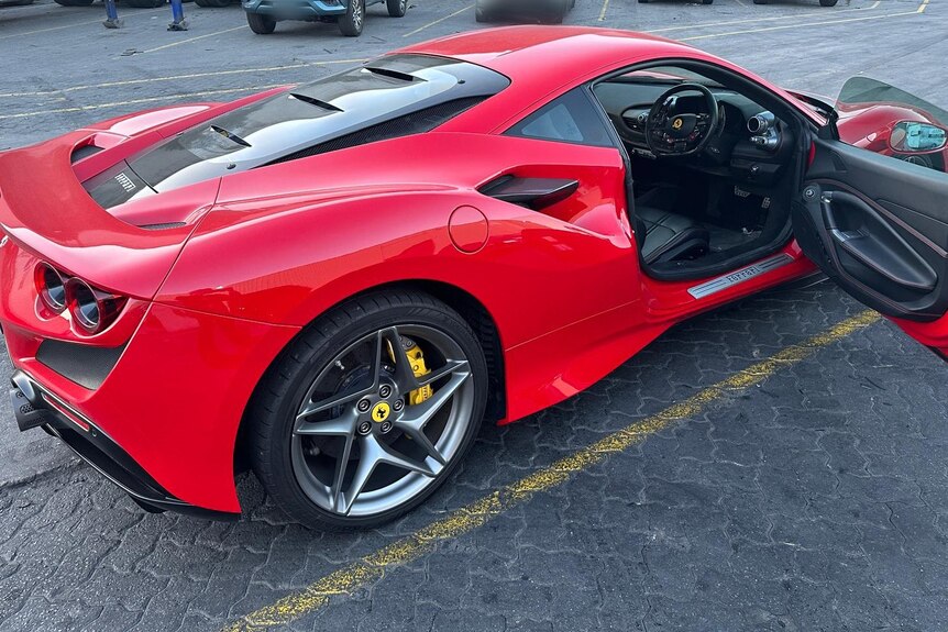A red Ferrari car with its door open