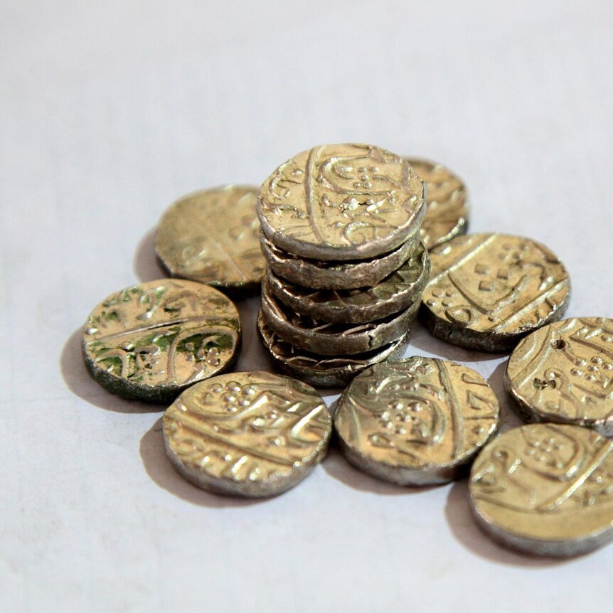 Several coins stacked on top of each other on a white table.