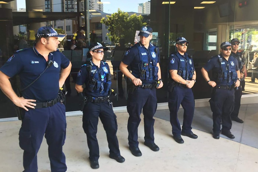 A line of police standing outside Southport magistrates court