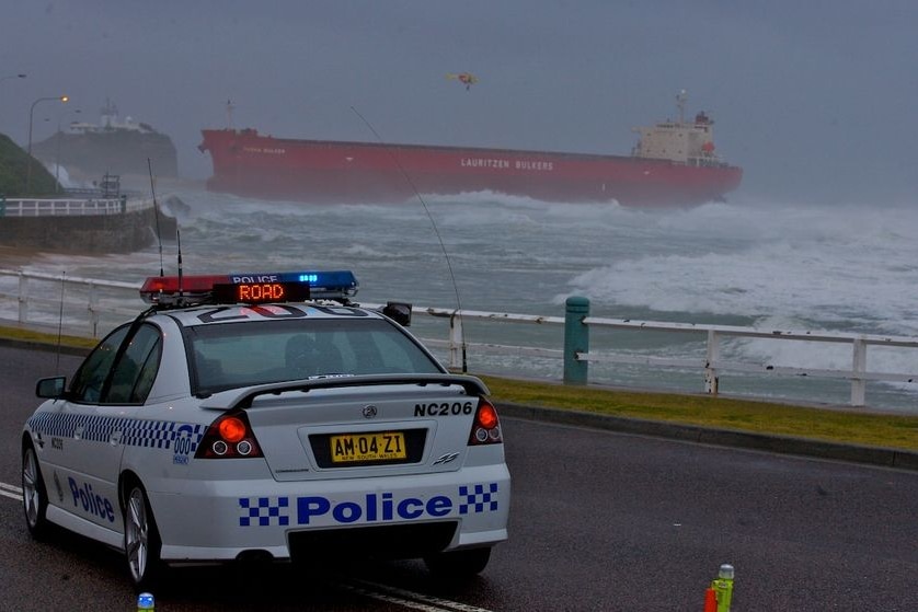 A police car blocks the road in front of stricken coal freighter MV Pasha Bulker.