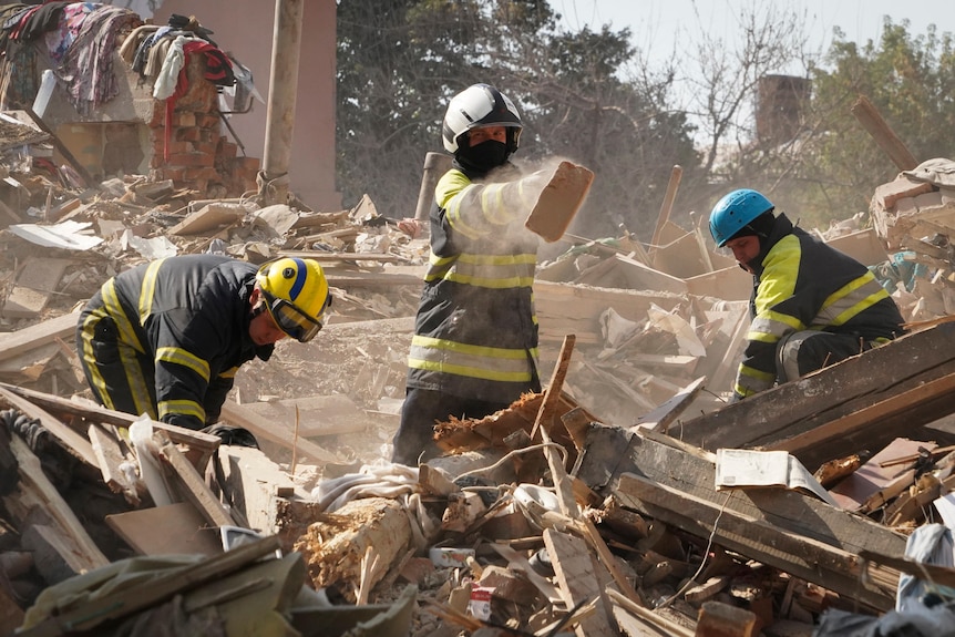 Firefighters dig through the rubble of a destroyed building