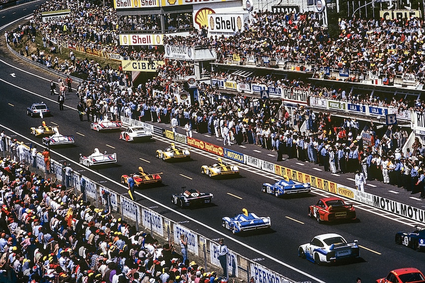 A picture from high on the grandstand shows the cars lining up to start the 24 Hours of Le Mans, with thousands watching.
