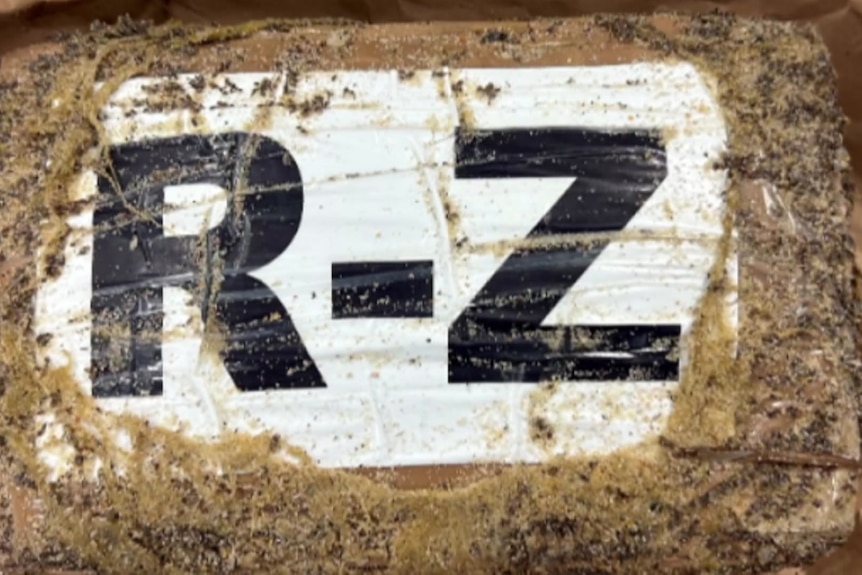 Brick shape covered in white tape and sand with the letters 'R' and 'Z'. 
