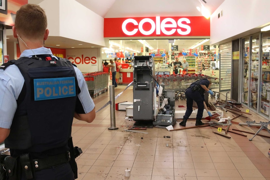 A damages ATM and broken bench seat in a shopping centre. Police are collecting evidence.