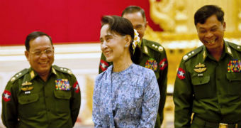 Aung San Suu Kyi smiles with army members.