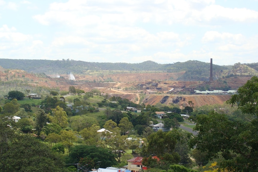 A view overlooking a regional town with a mine in the background.