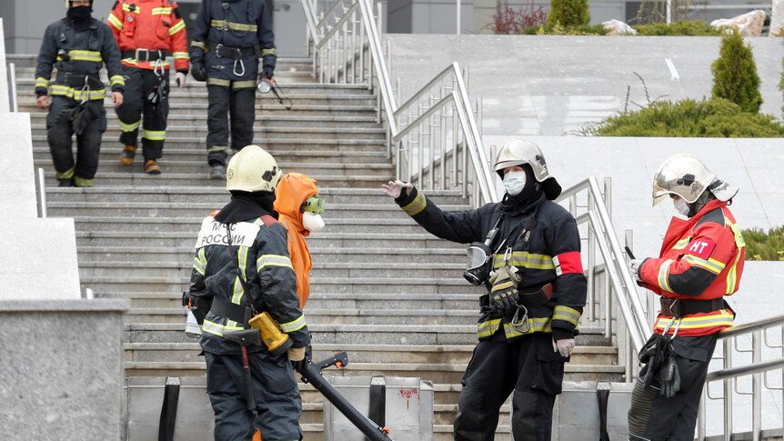 Firefighters talking on the steps of a Russian hospital