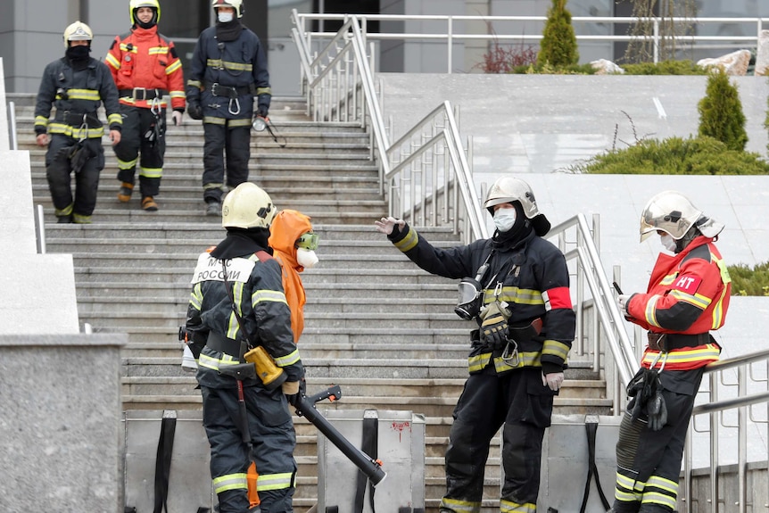 Firefighters talking on the steps of a Russian hospital